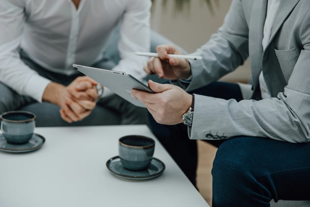 Two business people sitting and discussing over tablet