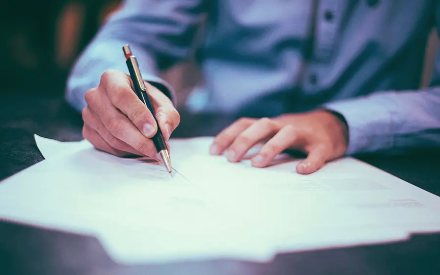 Person sitting at a desk filling out paperwork