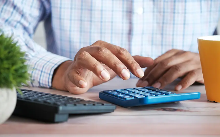 Business person sitting typing on calculator